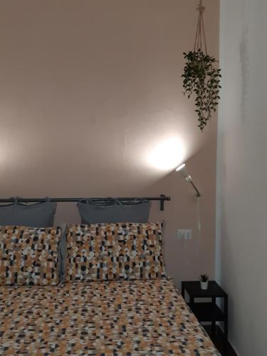 een slaapkamer met een bed en een lampje aan de muur bij Sa Calla Manna in Portoscuso