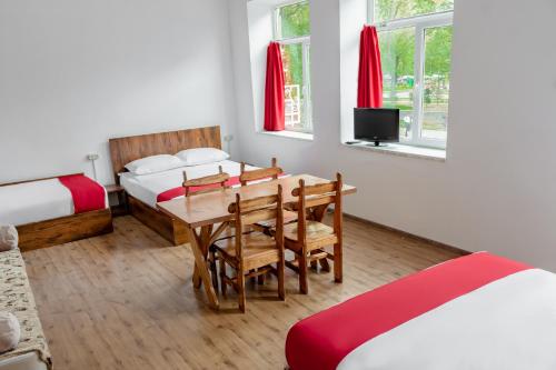a room with a table and chairs and a bed and a television at Family Appartments on Buzand street in Yerevan