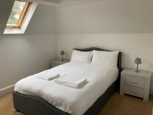 a bedroom with a bed with two towels on it at Letting Serviced Apartments - Chorleywood Village in Chorleywood