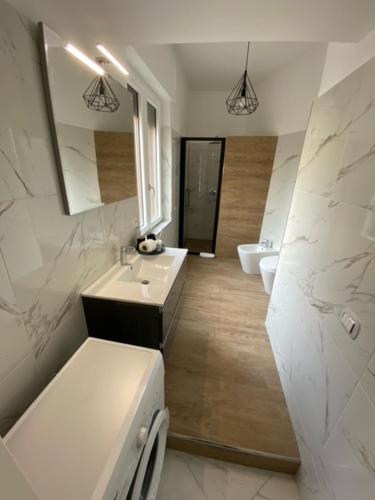 biała łazienka z umywalką i lustrem w obiekcie Maison Bisou w Sorrento