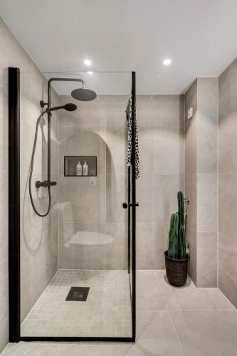 a shower with a glass door in a bathroom at Cozy room in City center in Trondheim