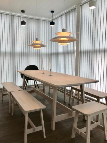 a table and benches in a room with windows at Day Dream Soleyjargata Rooms & Apartments in Reykjavík