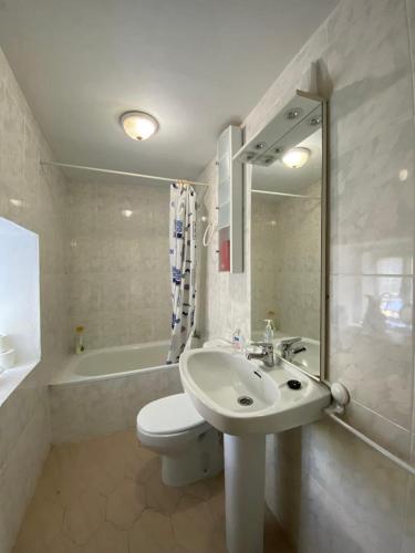 a bathroom with a sink and a toilet and a tub at Casa Hortiñas in Chancelas