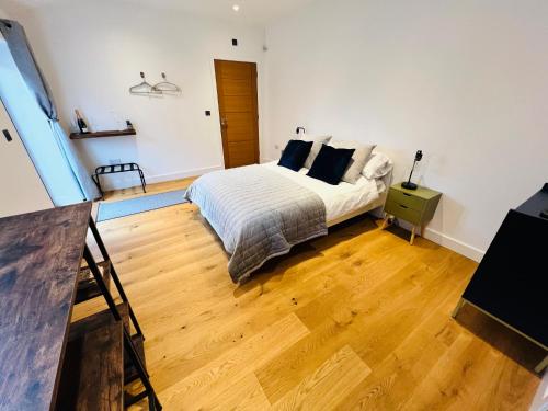 a bedroom with a bed and a wooden floor at Lavender Retreat in Wrexham