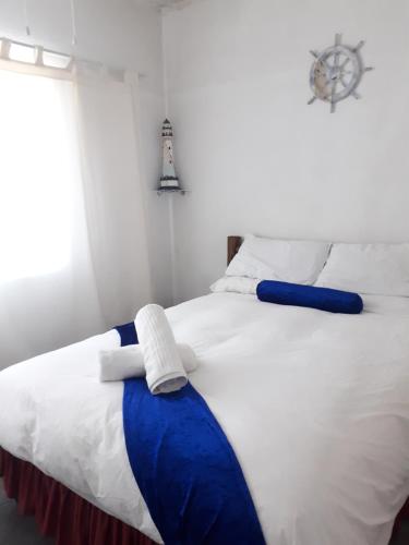 a bedroom with a large bed with blue and white sheets at Breezy Seaview-On the Beach- Open balcony in Amanzimtoti