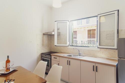a kitchen with a table and a sink and a window at Maria Olga Apartments in Benitses