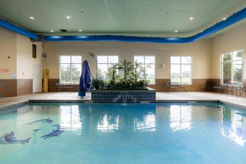 a large swimming pool with blue water in a building at Comfort Suites Troy-I75 in Troy