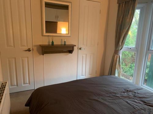 a bedroom with a bed next to a window at DaisyChain Getaways The perfect place to Stay Play and Getaway in East Mersea