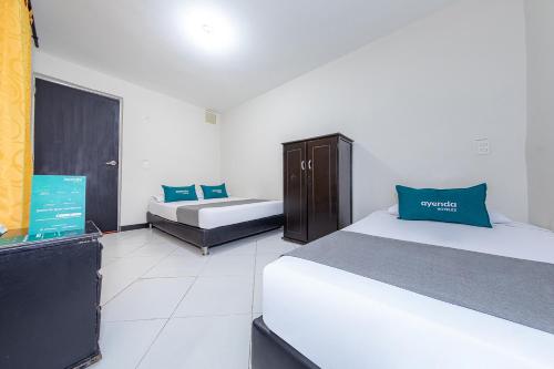 a hotel room with two beds and azeb sidx sidx sidx sidx sidx at Ayenda Vittapark in Medellín