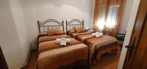 um quarto com 3 camas com cobertores castanhos e castanhos em Casa el corzo em La Iruela