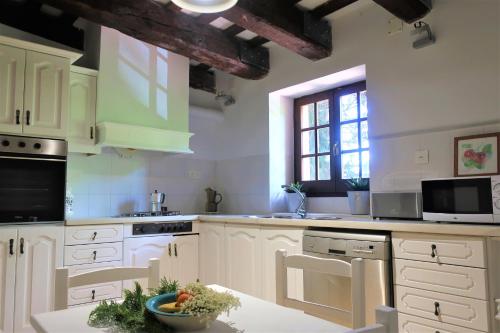 a kitchen with white cabinets and a bowl of fruit on the counter at Masia Sagués in Poblet