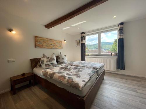 a bedroom with a bed and a large window at Maharaja Ferienhaus in Hemfurth-Edersee
