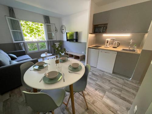 une cuisine et un salon avec une table et des chaises dans l'établissement La Parenthèse, Disneyland & Shopping, à Serris