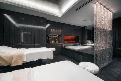 a bedroom with two beds and a tub and a sink at Paradox Vancouver in Vancouver