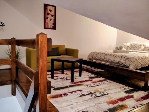 een slaapkamer met een bed, een bank en een tafel bij Lovely Central Apartment in Braşov