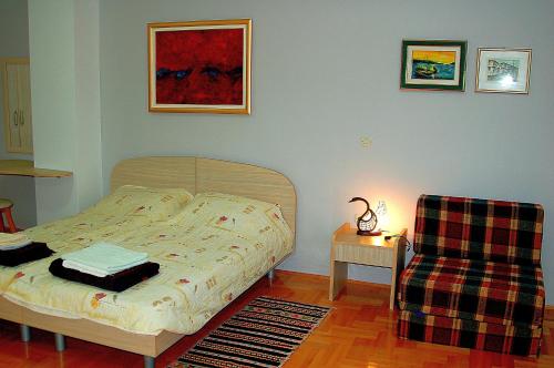 a bedroom with a bed and a chair at Apartment GORDANA in Ohrid