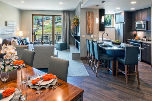 a kitchen and living room with a dining table and a kitchen and a living room at Grand Colorado on Peak 8 in Breckenridge