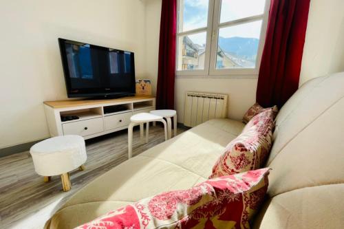 een woonkamer met een bank en een tv bij Bright 50 M With Balcony And View On The Valley in Briançon