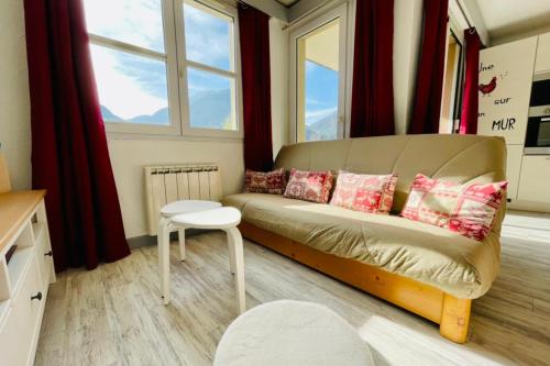 un salon avec un canapé et une fenêtre dans l'établissement LUMINEUX 50 m avec BALCON au centre de Briançon, à Briançon