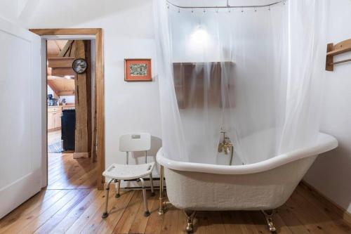 a white bath tub in a bathroom with a chair at Owl Street Lodge in Hope