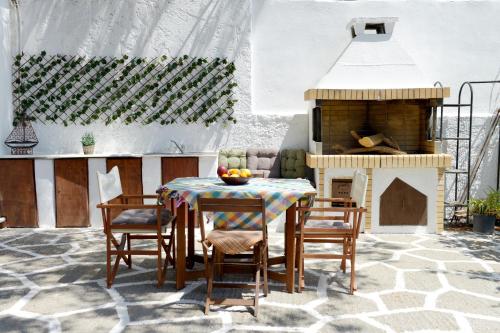 a patio with a table and chairs and a fireplace at Villa Nastazia in Kiotari