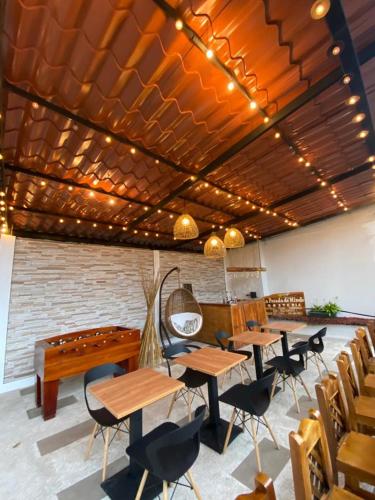 a dining room with tables and a pool table at La Posada de Mindo in Mindo