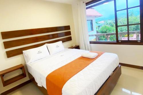 a bedroom with a large bed with a large window at La Posada de Mindo in Mindo