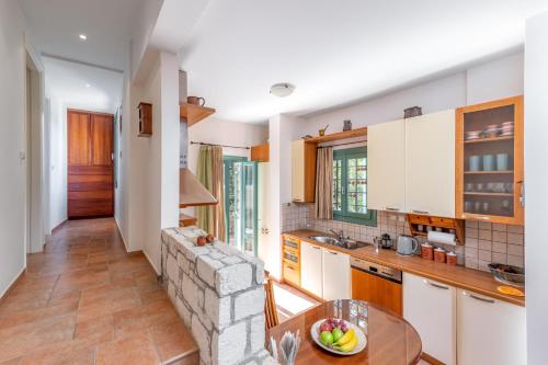 a kitchen with white cabinets and a table at bougainvilla in Fodele