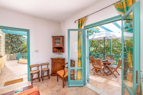 een kamer met een deur naar een patio met een tafel en stoelen bij bougainvilla in Fodele