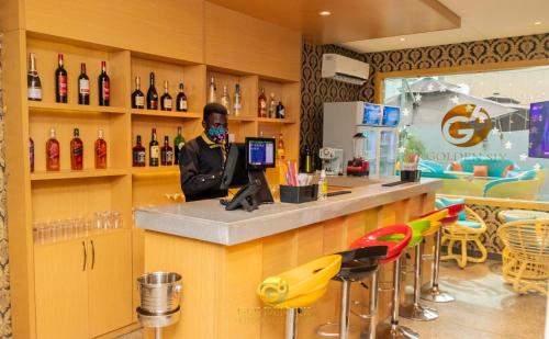 a man standing at a bar with a mask on at Golden Six Hotel and Restaurant in Lekki