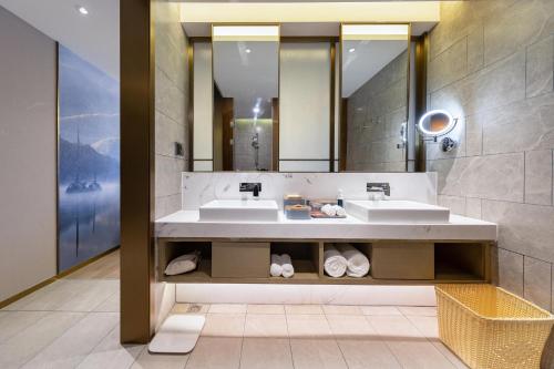 Un baño con dos lavabos y un espejo. en Atour S Hotel Wuhan Chuhehanjie, en Wuhan
