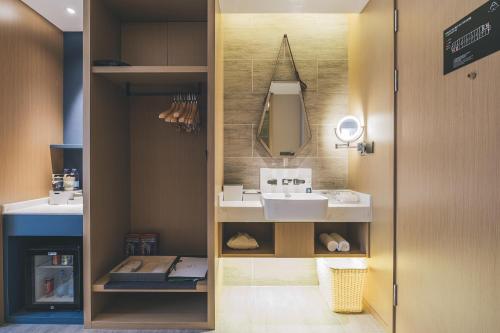 a bathroom with a sink and a mirror at Atour Hotel Shaoxing Shangyu E-Travel Town in Shaoxing