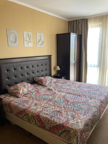 a bedroom with a bed with a colorful comforter at Barcelo Royal Beach Private Apartment in Sunny Beach