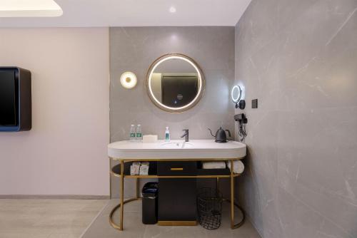 a bathroom with a sink and a mirror at Atour Light Hotel Qingdao International Convention Center in Qingdao