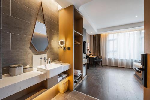 a bathroom with a sink and a mirror at Atour Hotel Chifeng Hongshan Sport Center in Chifeng