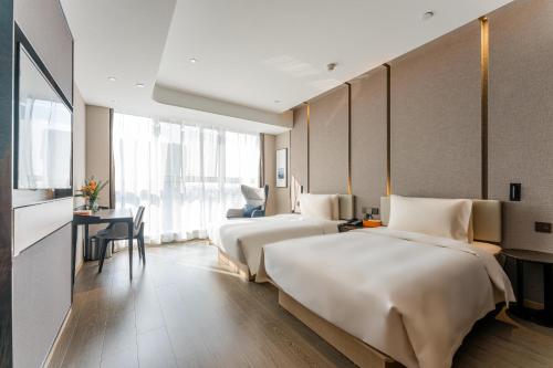 a hotel room with two beds and a desk at Atour Hotel Yiwu International Trade Transportation Center in Yiwu