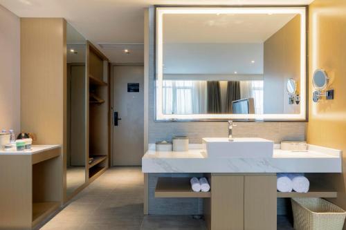bagno con lavandino e specchio di Atour Hotel Zhangjiajie Tianmen Mountain a Zhangjiajie