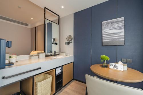 a bathroom with a sink and a wooden table at Atour Hotel Hangzhou West Lake Hubin North Zhongshan Road in Hangzhou