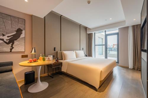 Habitación de hotel con cama y mesa en Atour Hotel Shijiazhuang East Zhongshan Road, en Shijiazhuang