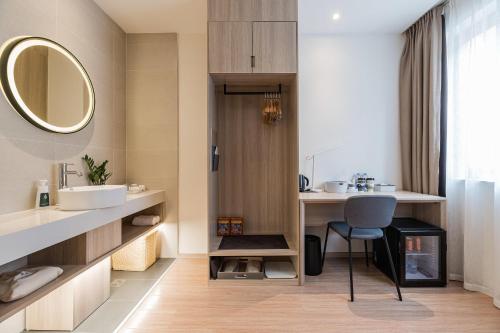 La salle de bains est pourvue d'un lavabo et d'un miroir. dans l'établissement Atour Light Hotel Nantong West Youth Road, à Nantong