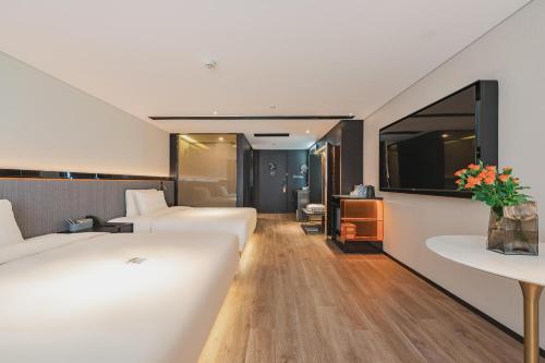a hotel room with two beds and a tv at Atour S Hotel Wuxi Nanchang Street in Wuxi