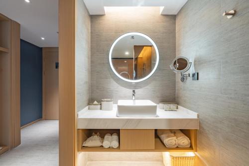 een badkamer met een wastafel en een spiegel bij Atour Hotel Huai an Suning Plaza Dazhi Road in Huai'an