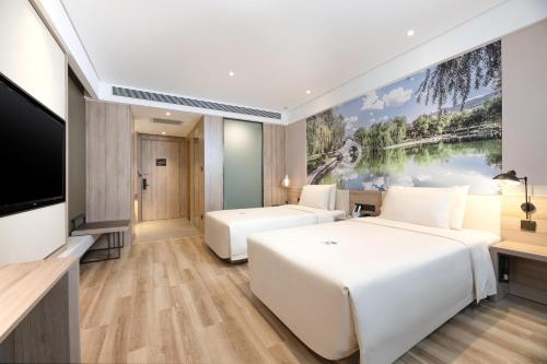 a hotel room with two beds and a flat screen tv at Atour Hotel Xian Xianyang International Airport in Xi'an