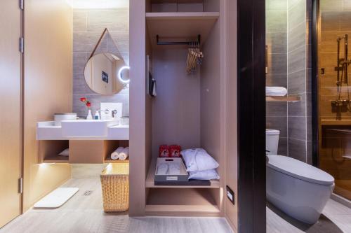Atour Hotel Jincheng Development Lanhua Road في Jingcheng: حمام مع مرحاض ومغسلة