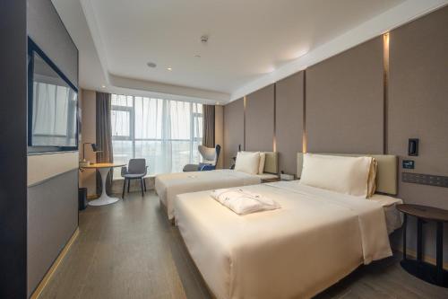 a hotel room with two beds and a desk at Atour Hotel Dongguan Songhan Lake in Dongguan