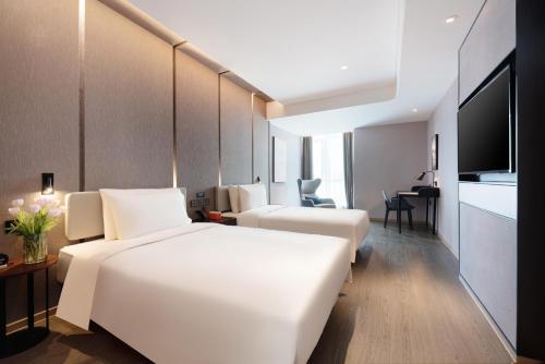a hotel room with two beds and a flat screen tv at Atour Hotel Lanzhou Xiguan Zhangye Road Pedestrian Street in Lanzhou