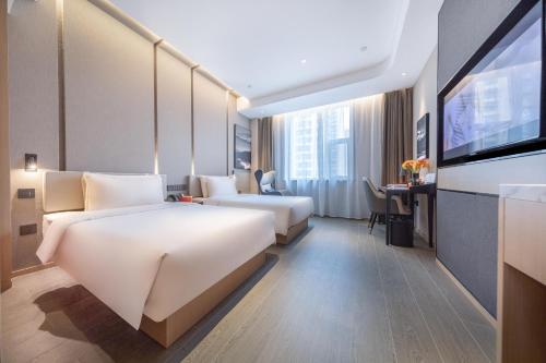 太原的住宿－太原长风商务区万象城亚朵酒店，酒店客房设有两张床和一台平面电视。