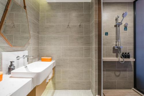a bathroom with a sink and a shower at Atour Hotel Shijiazhuang South Construction Street in Shijiazhuang