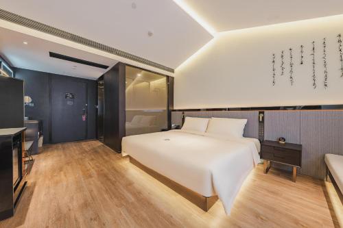 a bedroom with a large white bed and a couch at Atour S Hotel Wuxi Nanchang Street in Wuxi
