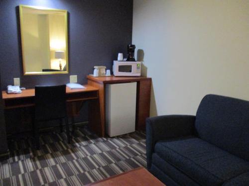 a room with a desk and a chair and a microwave at Microtel Inn and Suites - Inver Grove Heights in Inver Grove Heights